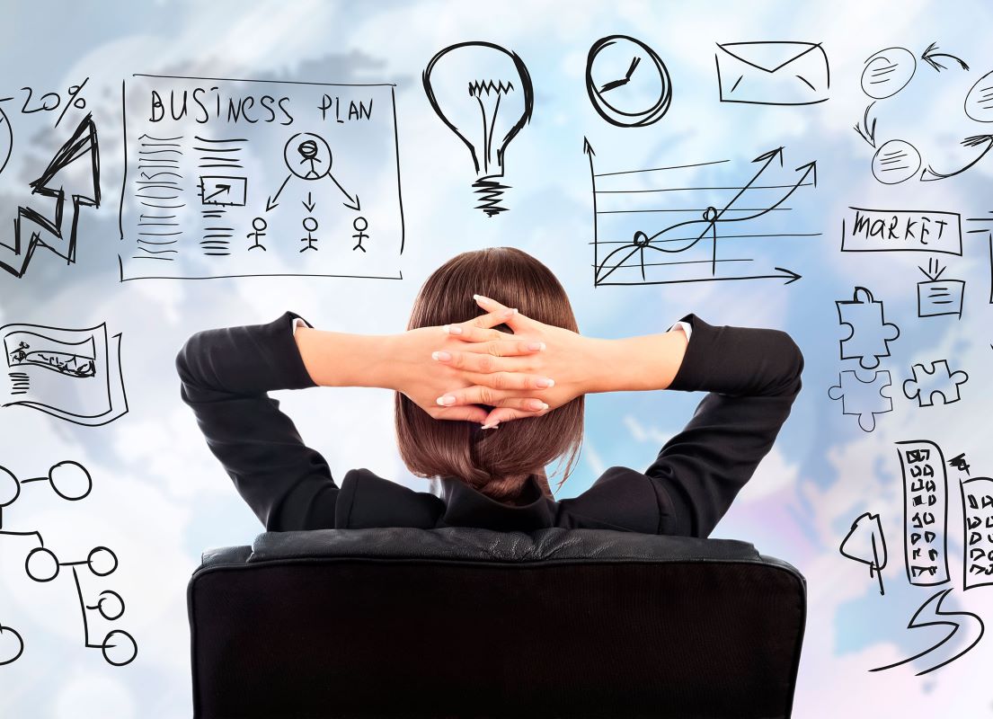 A woman sits and watches a whiteboard