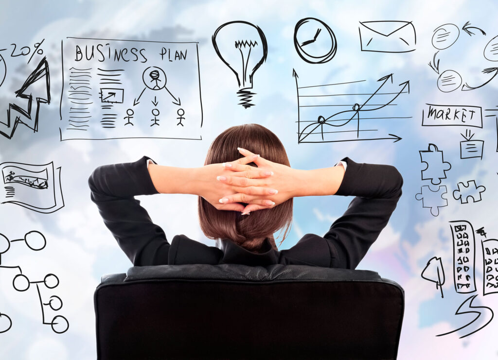 A woman sits and watches a whiteboard full of texts and graphics