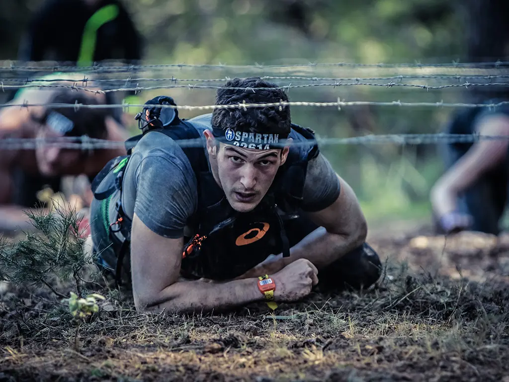 a man crawl under barbed wire