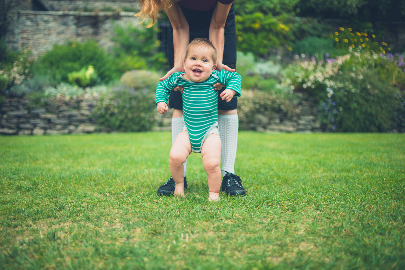 a baby is walking with the of his mother